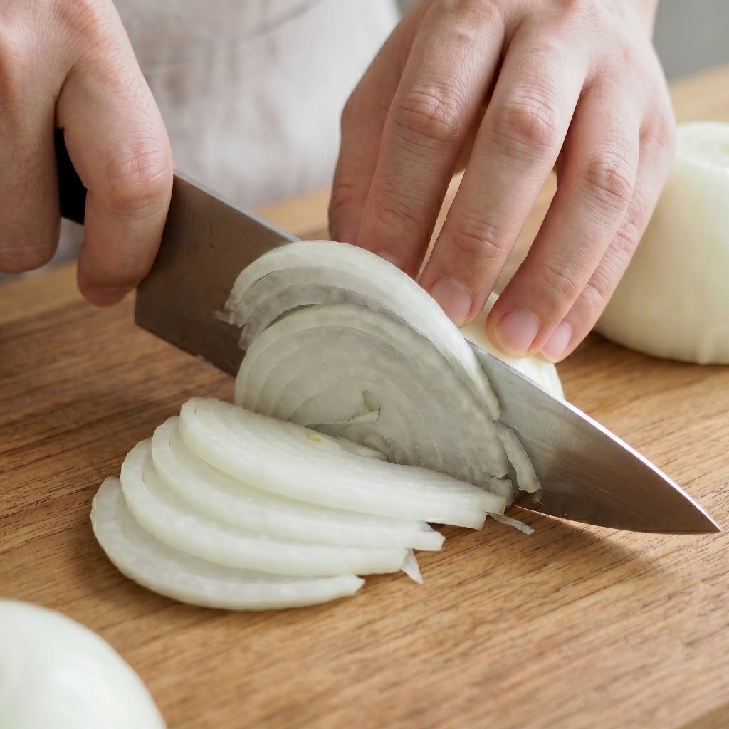 이연복 두부냉채 재료 준비 - 매운맛이 적은 신선한 햇양파를 얇게 채 써는 모습