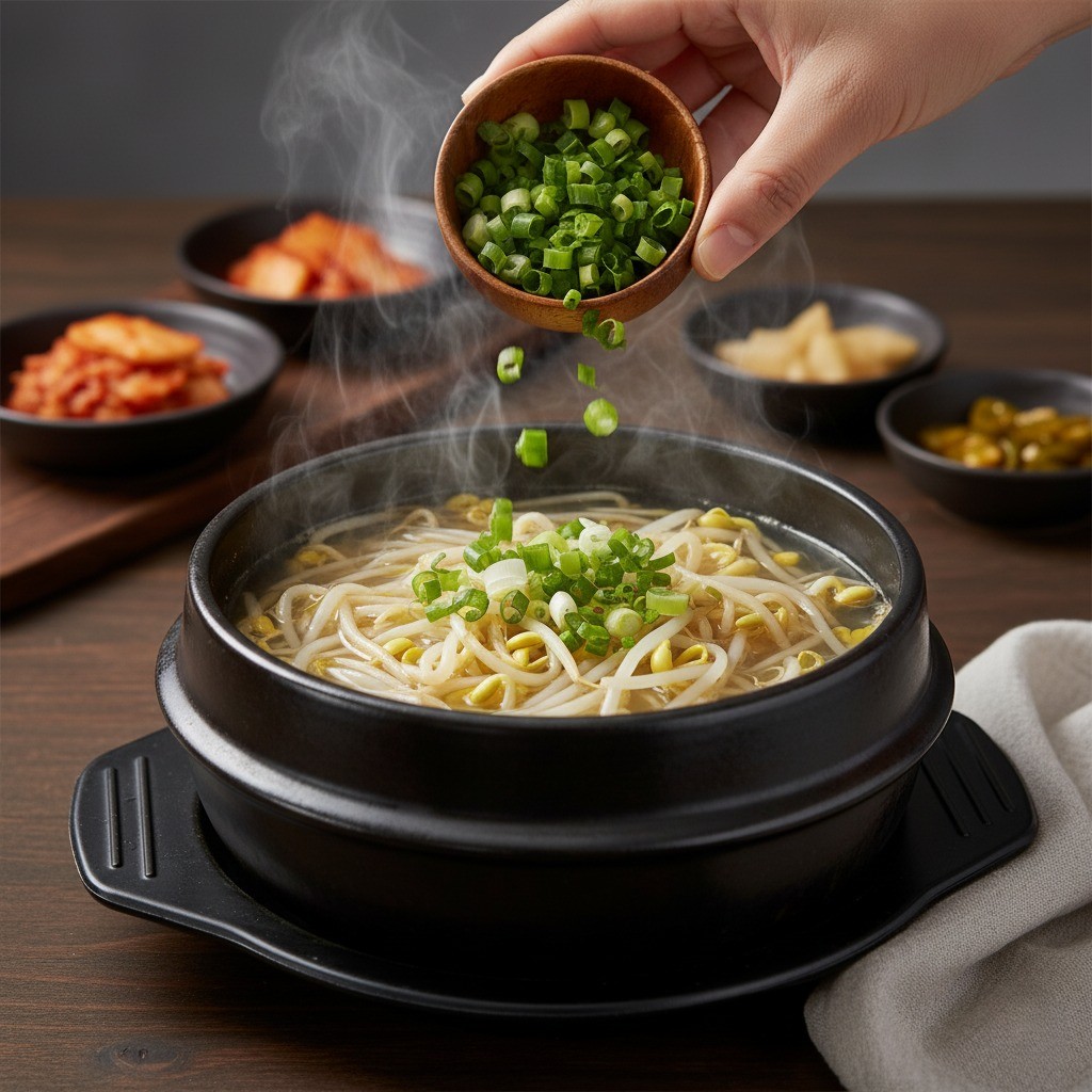 콩나물국에 쪽파를 넣어 완성하는 모습