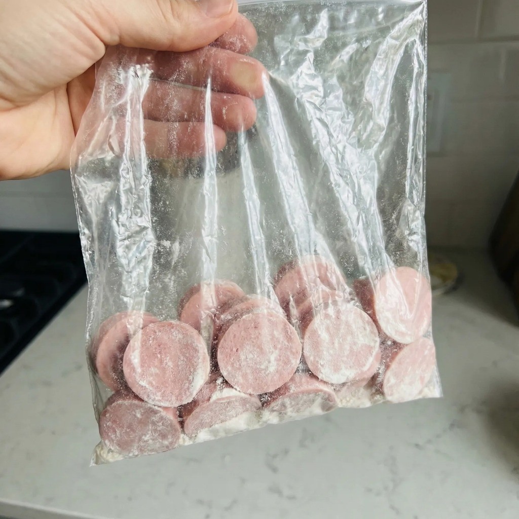 비닐봉지에 분홍 소세지와 부침가루를 넣고 흔들어 얇게 밀가루 옷을 입히는 꿀팁