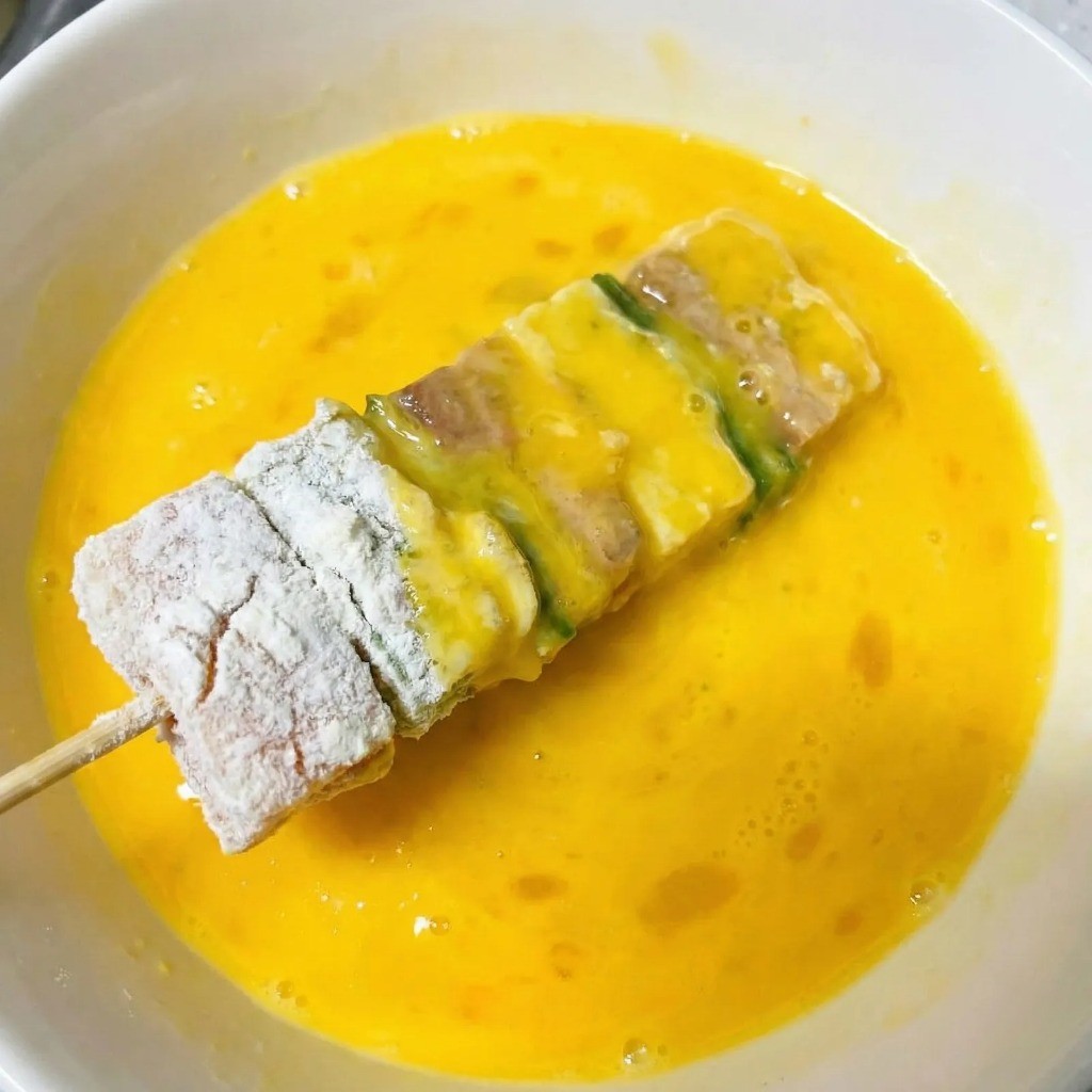 달걀물 입히기 - 소금과 참기름으로 간을 한 달걀물에 꼬치 담그기