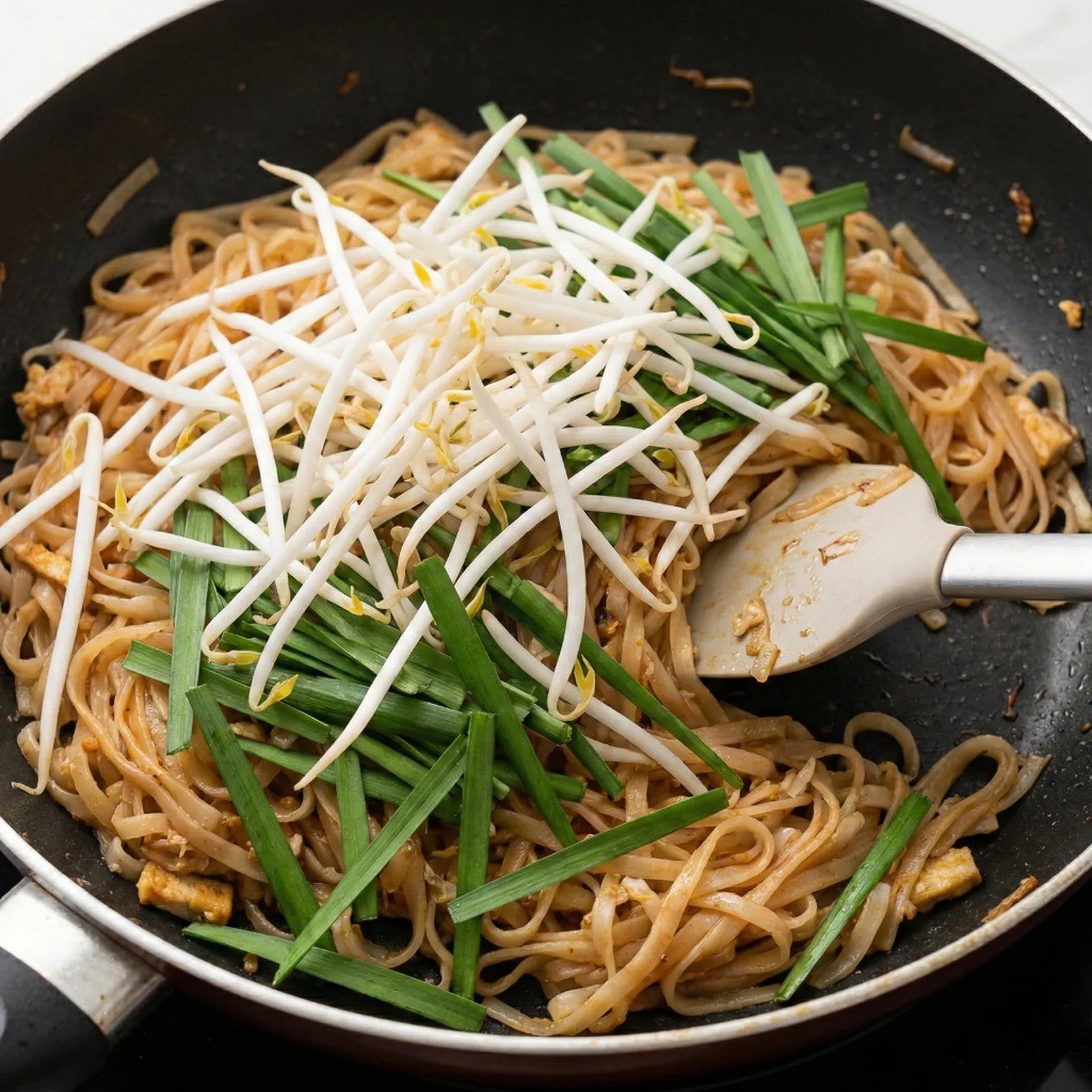 팟타이 완성 단계: 숙주와 부추를 넣고 잔열로 가볍게 섞어 아삭한 식감 살리기