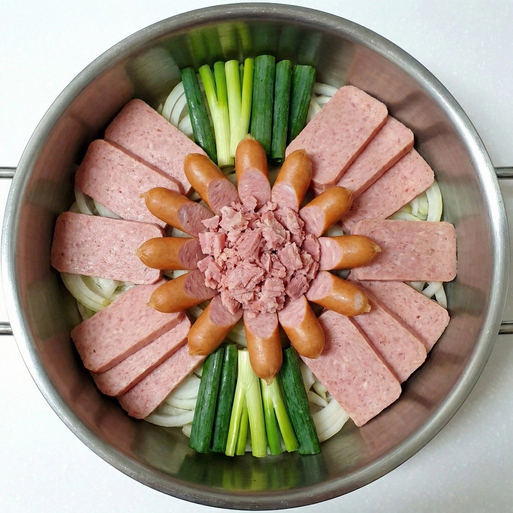 부대찌개 냄비 세팅 - 전골 냄비에 햄, 소시지, 채소를 둥글게 플레이팅한 모습