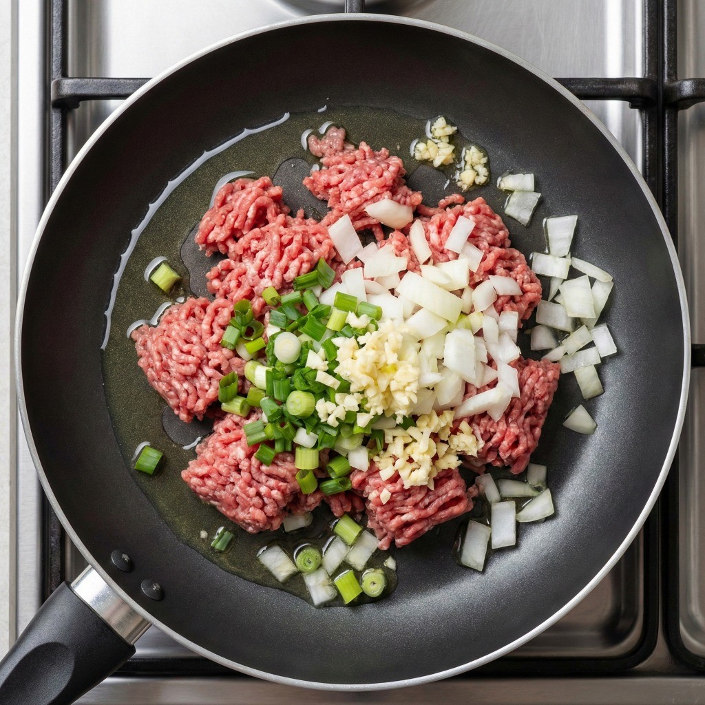 볶음고추장 재료 손질: 팬에 담긴 다진 소고기, 양파, 대파, 간마늘