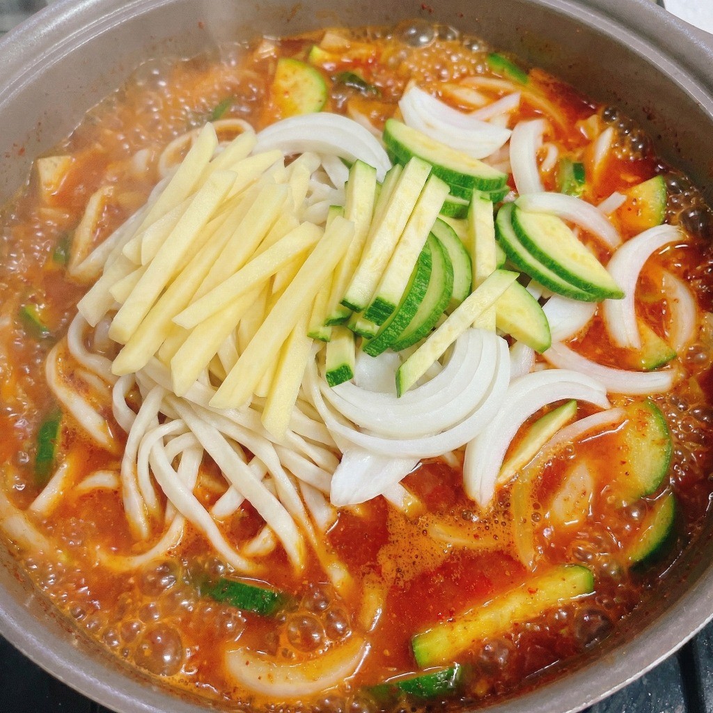 끓는 육수에 칼국수 면과 애호박, 양파, 고추 넣는 조리 과정