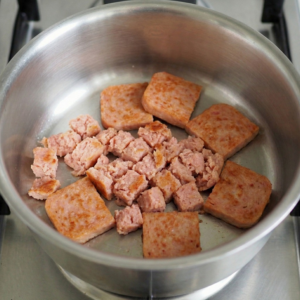 냄비에 기름 없이 으깬 햄과 썬 햄을 노릇하게 볶는 김치찌개 조리 과정