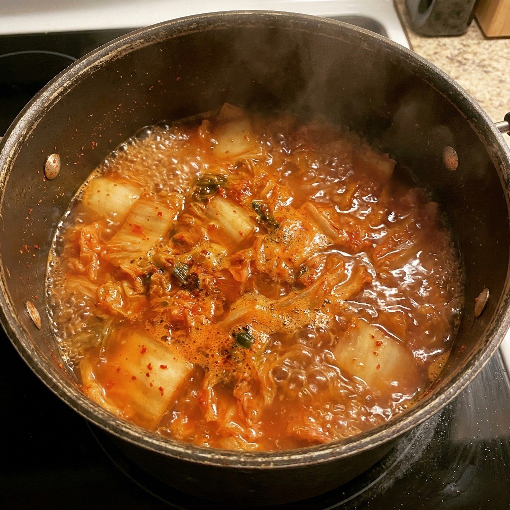 백종원 김치라면 끓이는 법 - 끓는 물에 신김치와 고춧가루, 라면 면발을 넣고 끓이는 과정