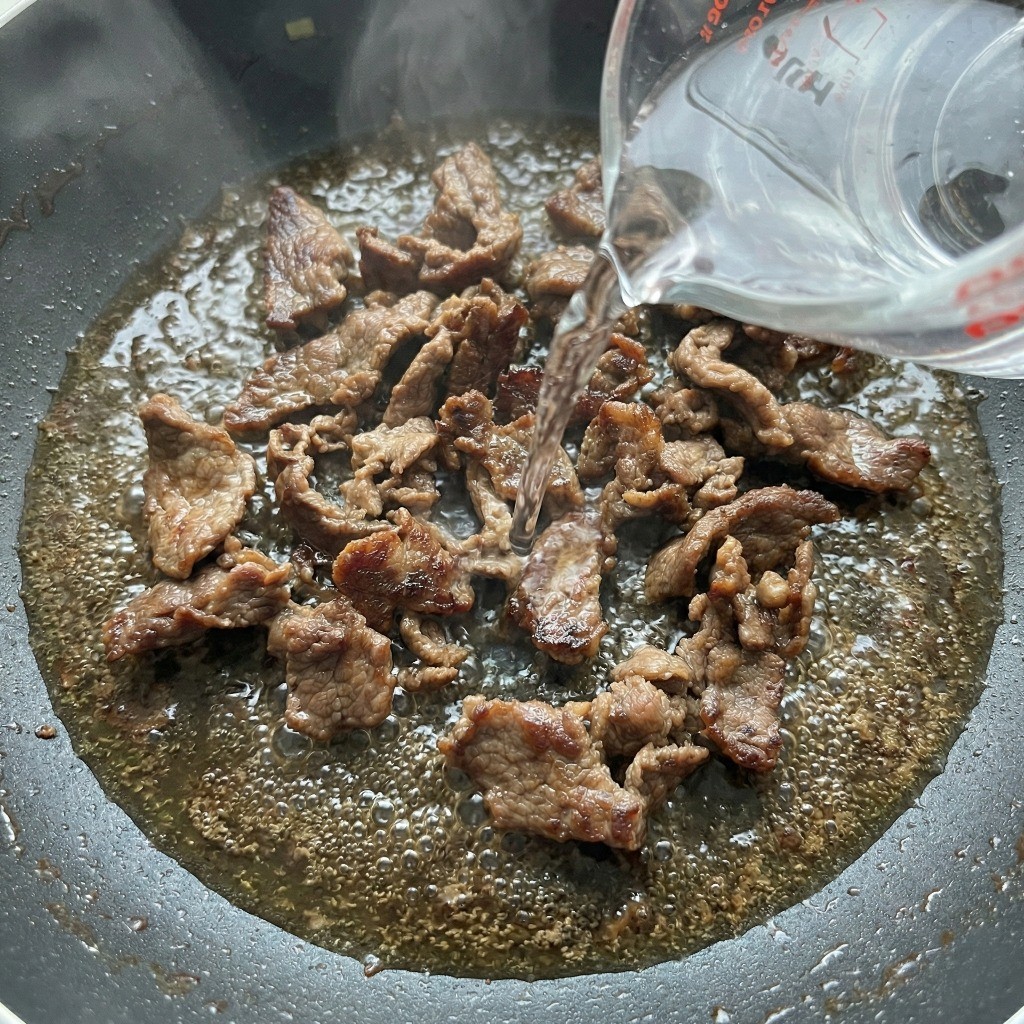 백종원 짜파구리 레시피 2단계: 볶은 불고기 위로 물 500ml를 부어 물 조절하는 모습