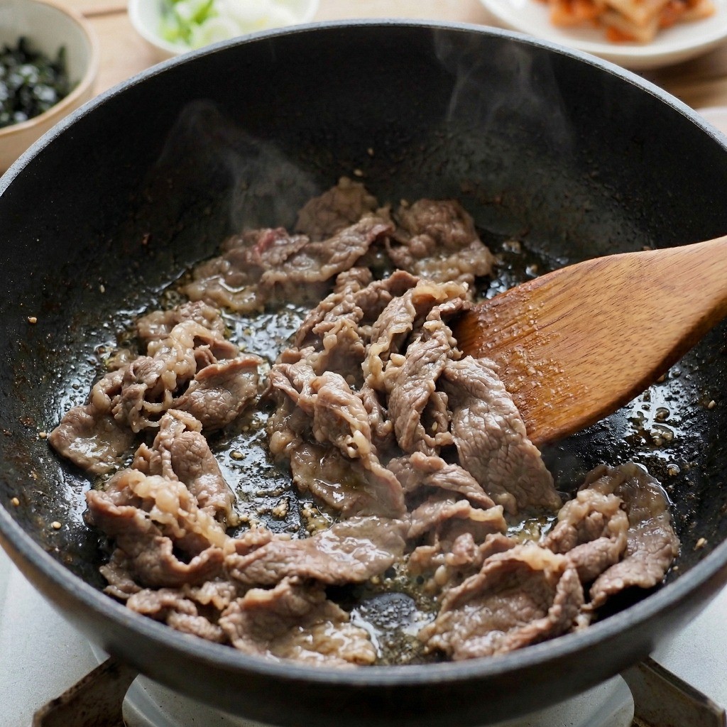 참기름을 두른 냄비에 소고기 불고기거리를 중약불로 볶는 모습