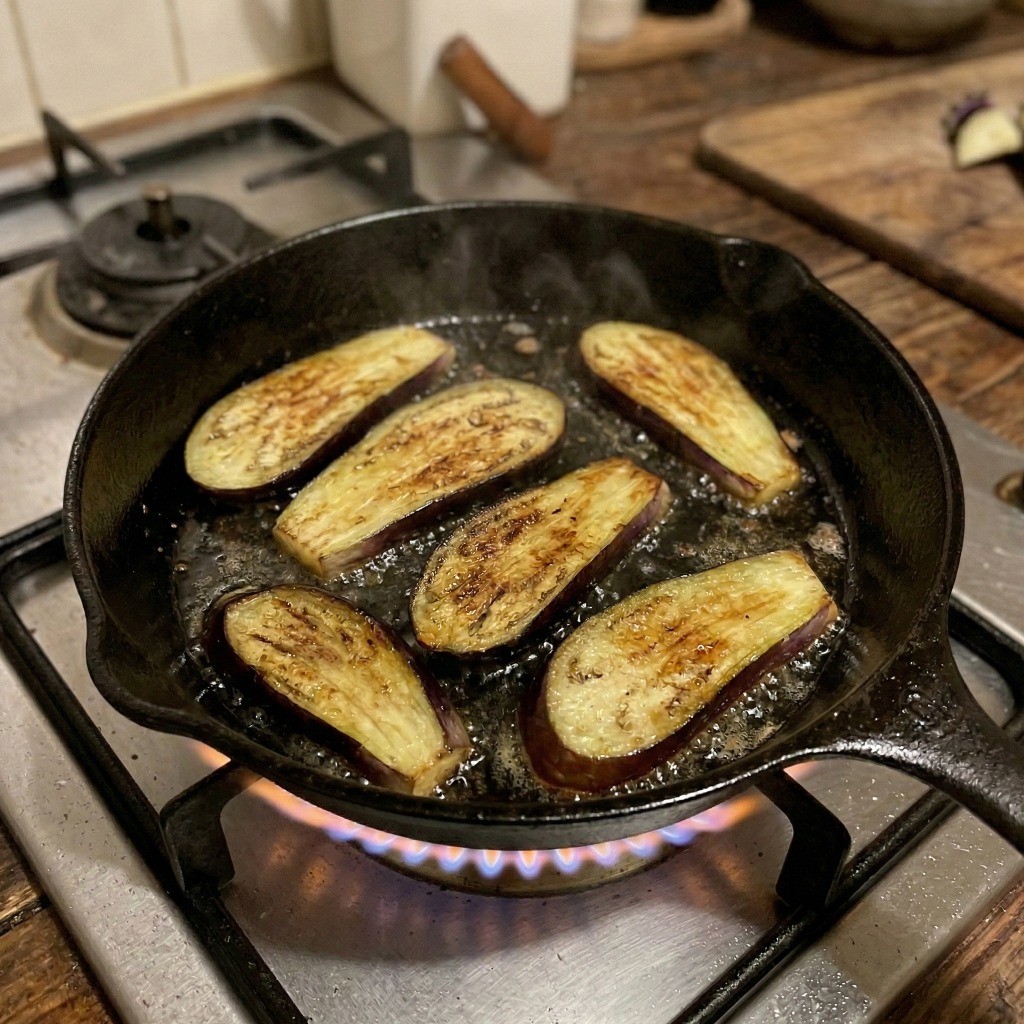 식용유를 두른 프라이팬에서 노릇하고 쫄깃하게 구워지는 가지구이 조리 과정