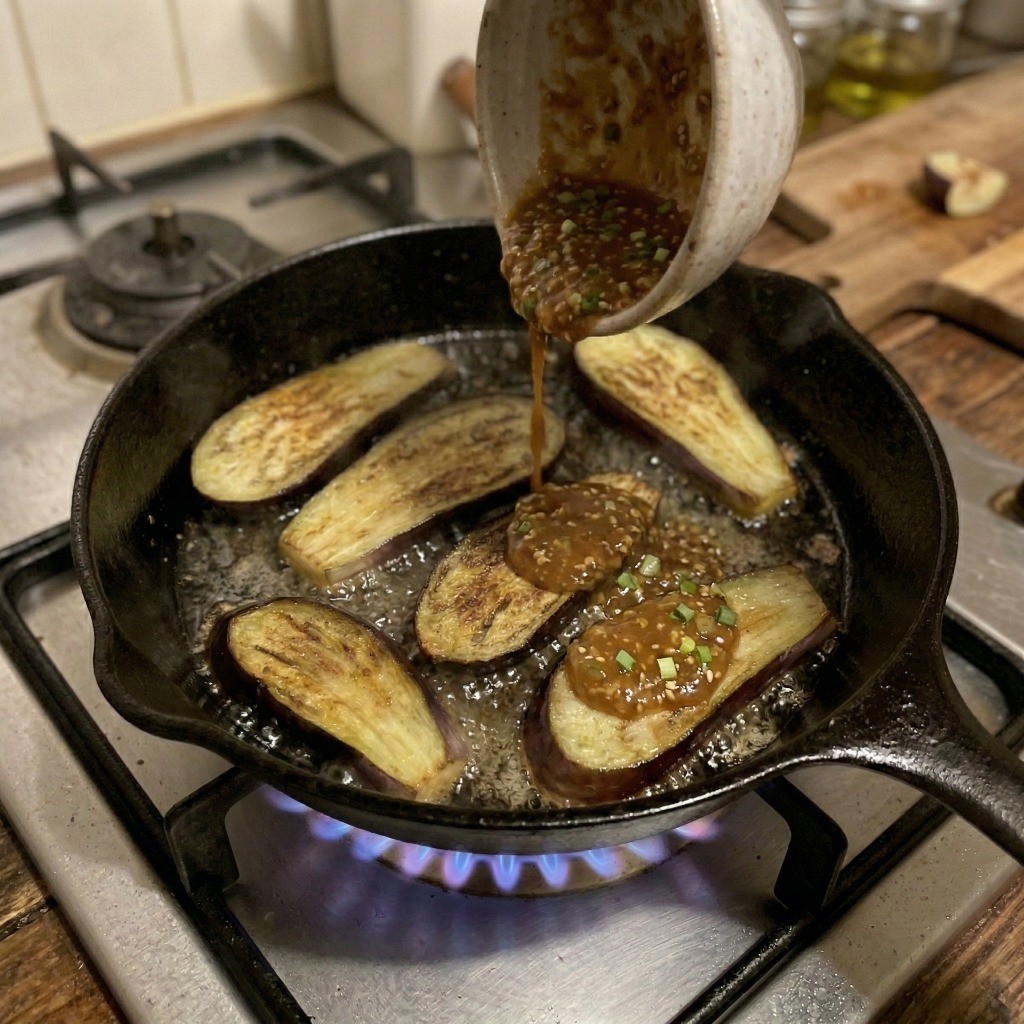 잘 구워진 가지 위에 된장 양념장을 붓고 윤기 나게 조리는 과정