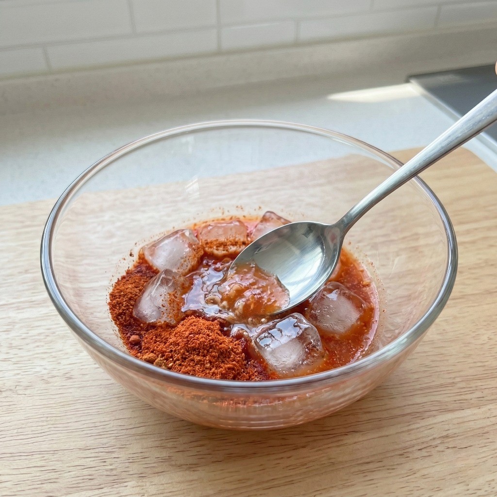 라면 스프와 각얼음을 물에 풀어 비법 냉면 육수를 만드는 냉라면 조리 2단계 모습