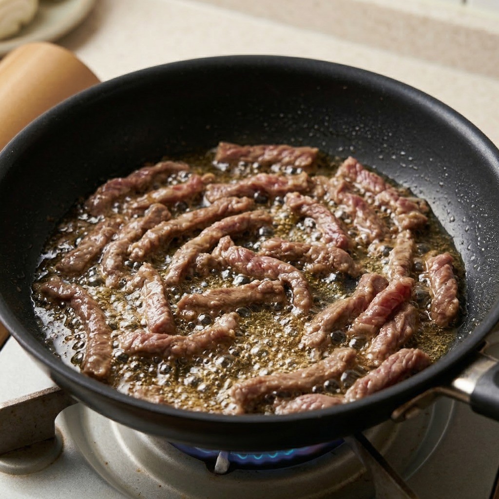 이연복 고추잡채 만들기 4단계: 전분 코팅된 소고기를 넉넉한 식용유에 타지 않게 볶아내는 과정