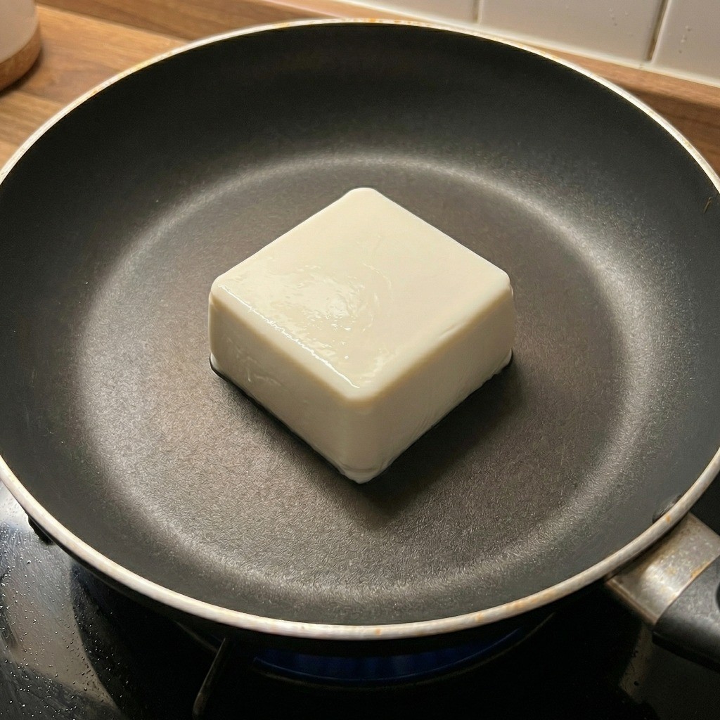 코팅된 프라이팬 정중앙에 연두부 한 모를 통째로 올린 조리 과정 2단계