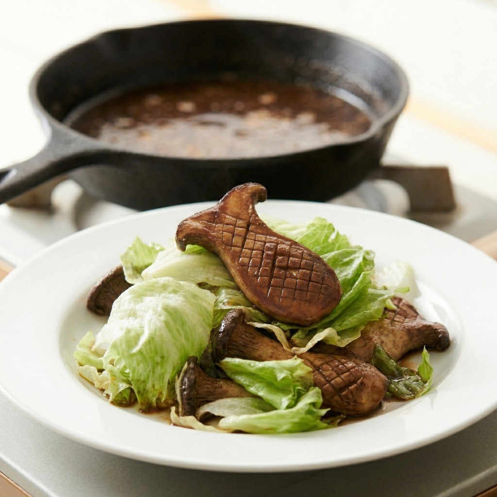 숨이 죽은 양상추와 버섯을 소스에서 건져내어 접시에 담은 모습