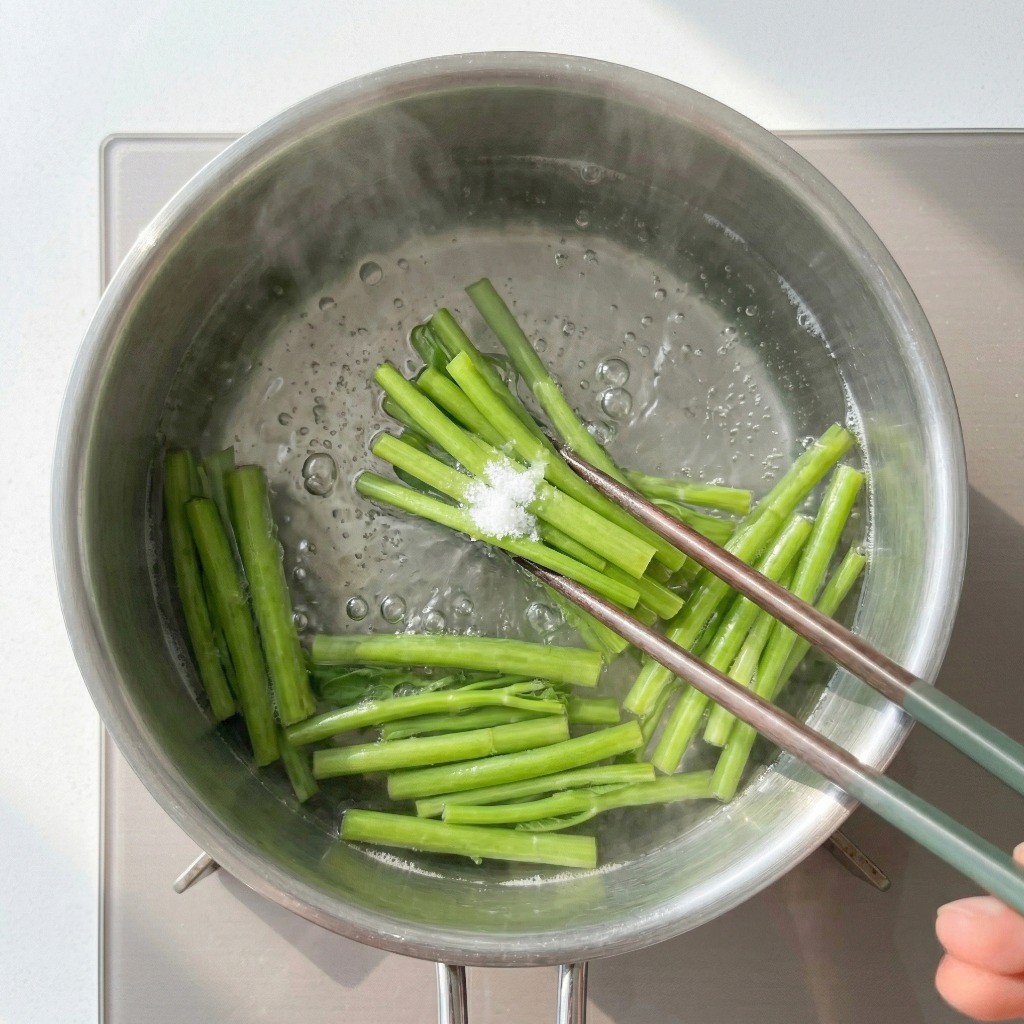 공심채 데치기: 끓는 소금물에 단단한 공심채 줄기를 먼저 넣고 데쳐 아삭함을 살리는 모습