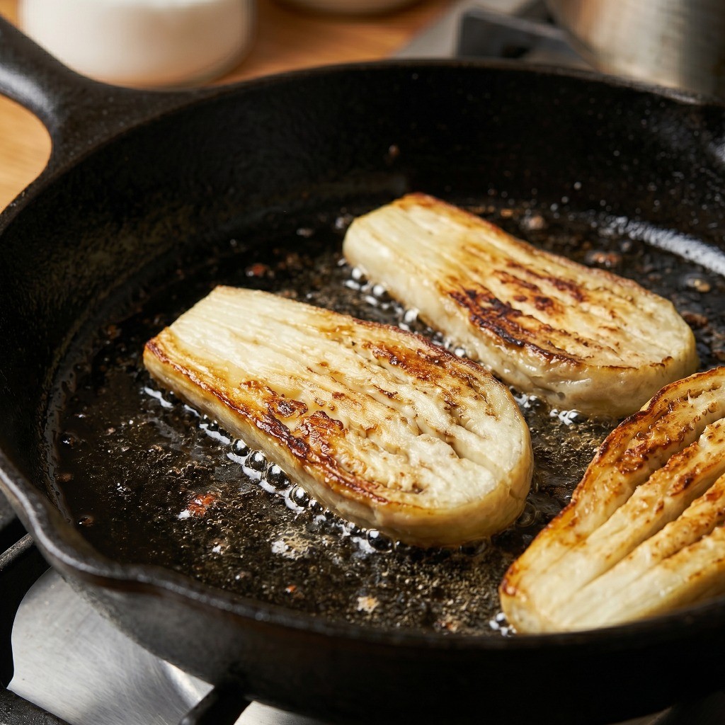 칼집 낸 가지 굽기: 식용유를 두른 프라이팬에 가지를 올려 장어구이처럼 노릇노릇하게 굽는 과정