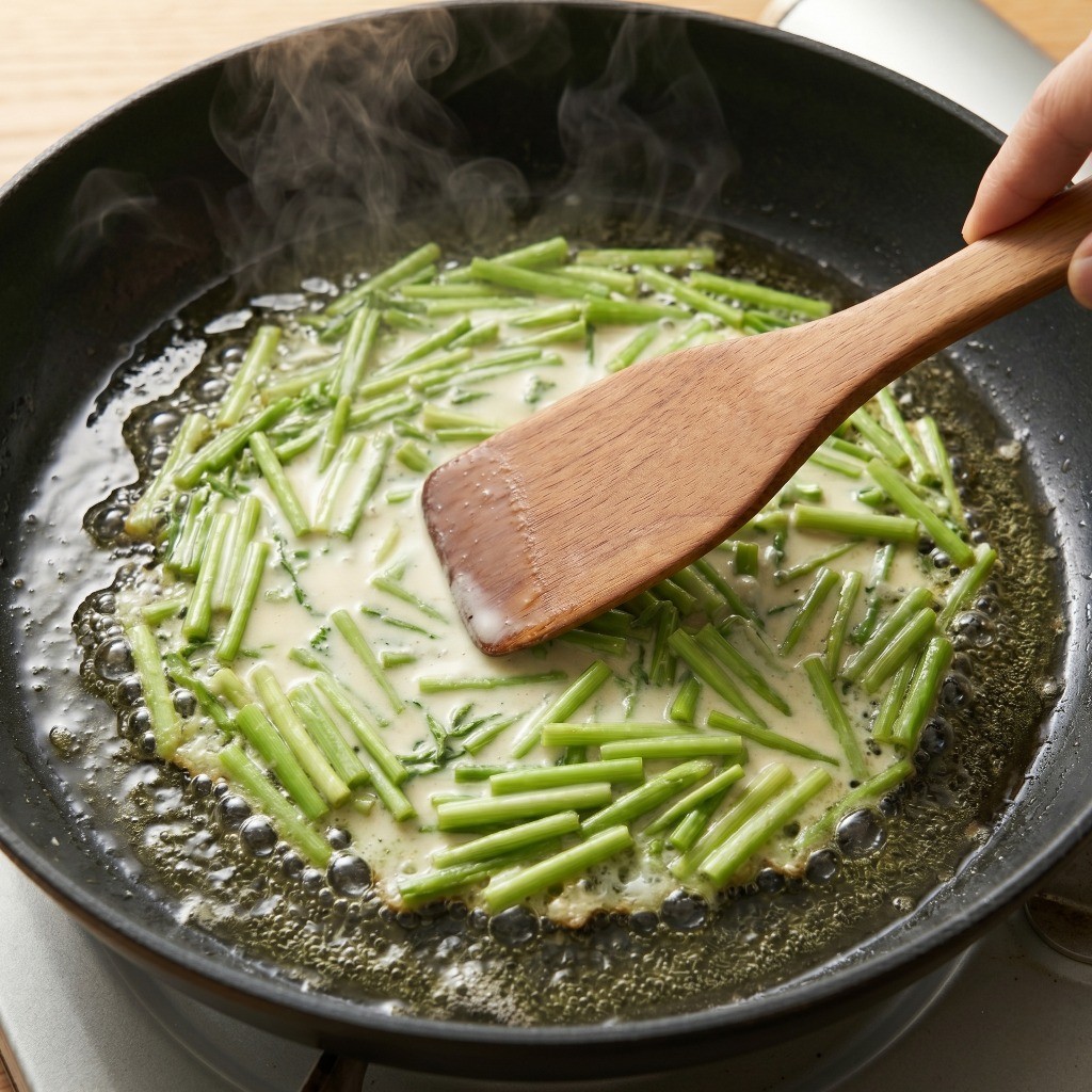 식용유를 넉넉히 두른 프라이팬에 미나리전 반죽을 얇게 펴서 굽는 모습