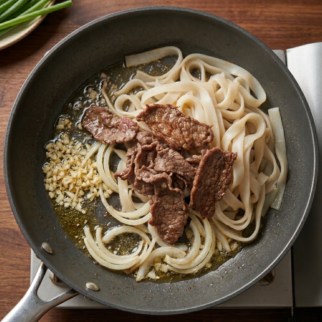 마늘과 양파로 파기름을 낸 후 미리 볶아둔 우삼겹과 쌀국수 면 합치기