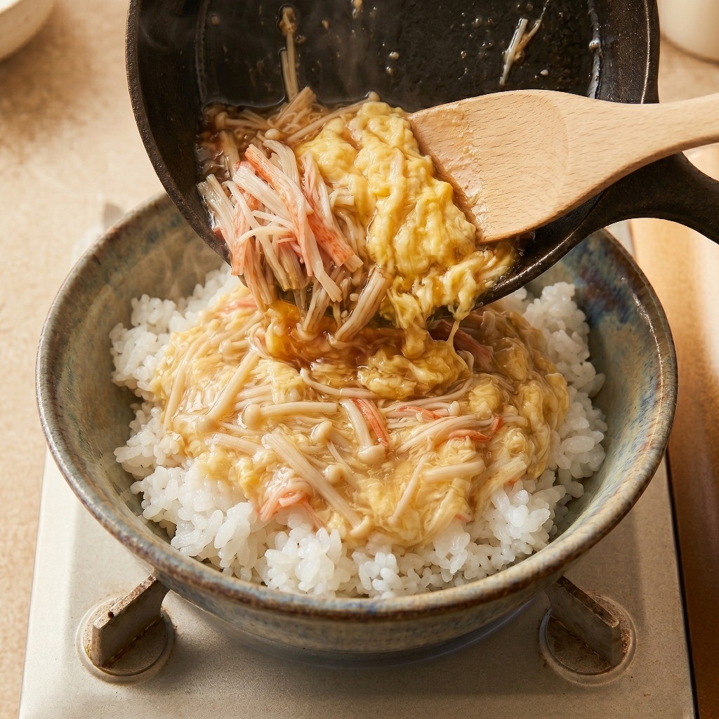 따뜻한 즉석밥 위에 완성된 부드러운 계란 소스를 듬뿍 올린 완성 모습