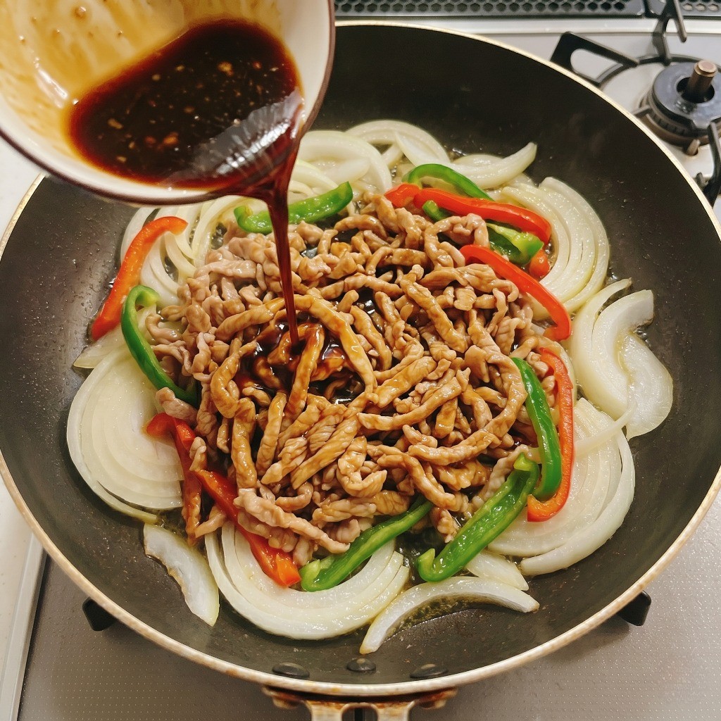 시판 요리킥 고추잡채 소스를 붓고 재료에 골고루 코팅하며 볶아 완성하는 모습