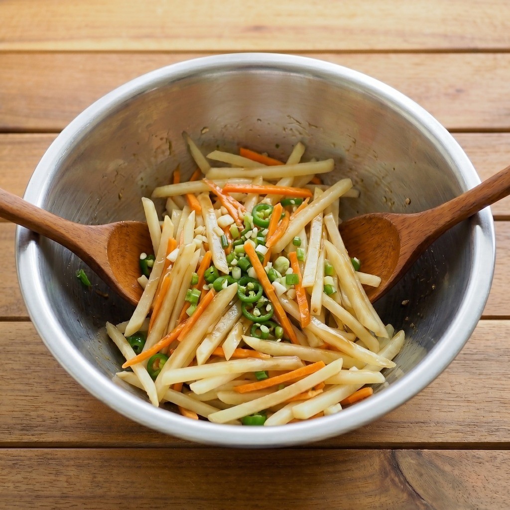 4단계: 감자채무침 양념 버무리기 - 굴소스, 참기름 등의 양념과 채소를 넣고 조물조물 무쳐 완성하는 모습