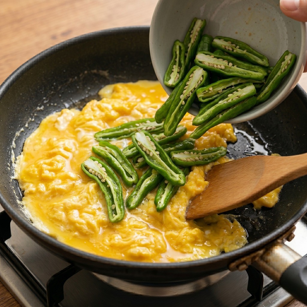 이연복 꽈리고추 계란볶음 레시피 4단계: 반쯤 익은 스크램블 에그에 볶아둔 꽈리고추를 섞어 완성하는 모습