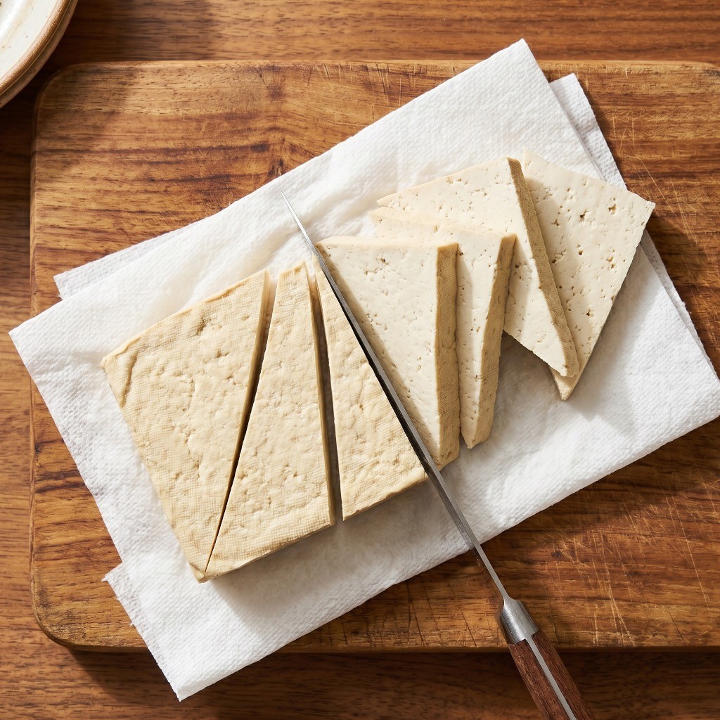 이연복 가상두부 레시피 1단계: 부침용 두부를 삼각형으로 두툼하게 썰어 키친타월로 수분을 제거하는 모습