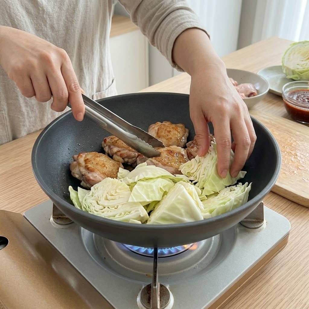 궁중팬 바닥에 양배추를 넉넉히 깔고 그 위에 구운 닭을 얹은 모습